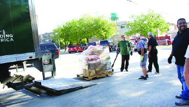 Church members receive food to stock the food pantry shelves with at Elmwood Park Community Church as part of their plan to reach out to a diverse community.