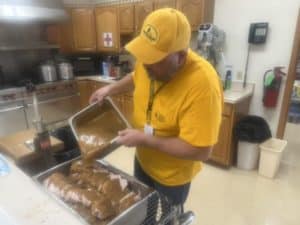 A member of an IBDR feeding team prepares a meal for other IBDR  volunteers in the kitchen of Highland Avenue Baptist Church in Robinson.