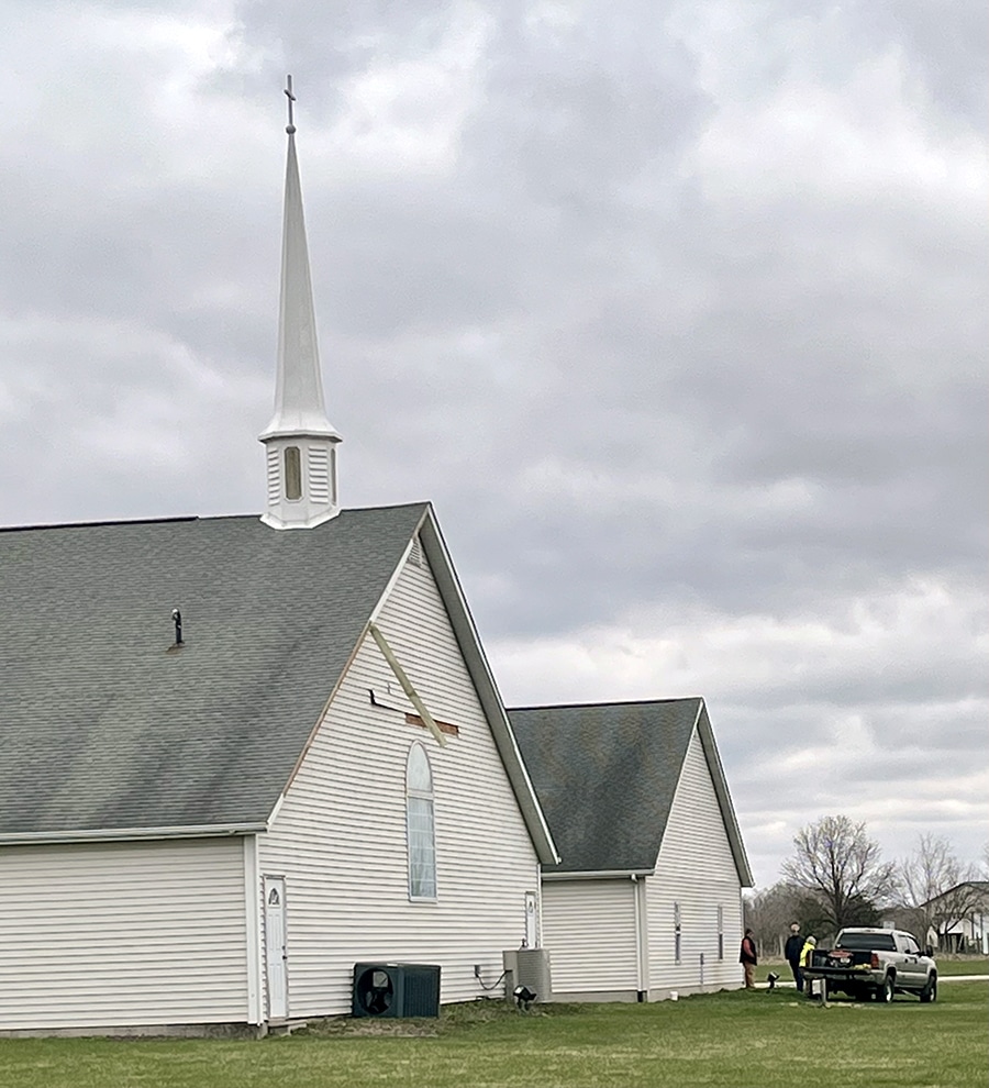 Members of Living Faith Baptist Church in Sherman survey exterior damage to the building caused by a tornado on March 31. Inside, the tornado moved walls in the fellowship hall and sanctuary out about 2 ½ inches.