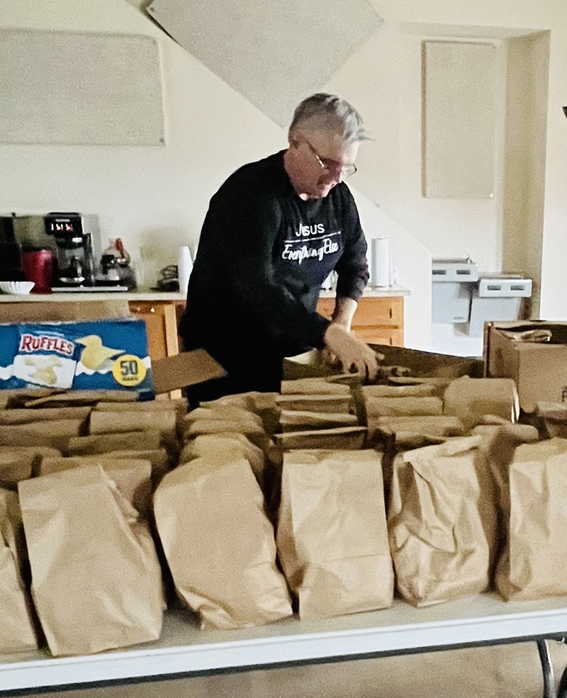 Living Faith Baptist’s Meal Coordinator Steve Miller packs grab-and-go sack lunches.