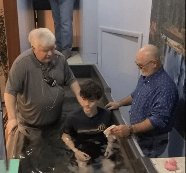 Pastor David Wright  baptizes his 300th person, Ashton Eddington.